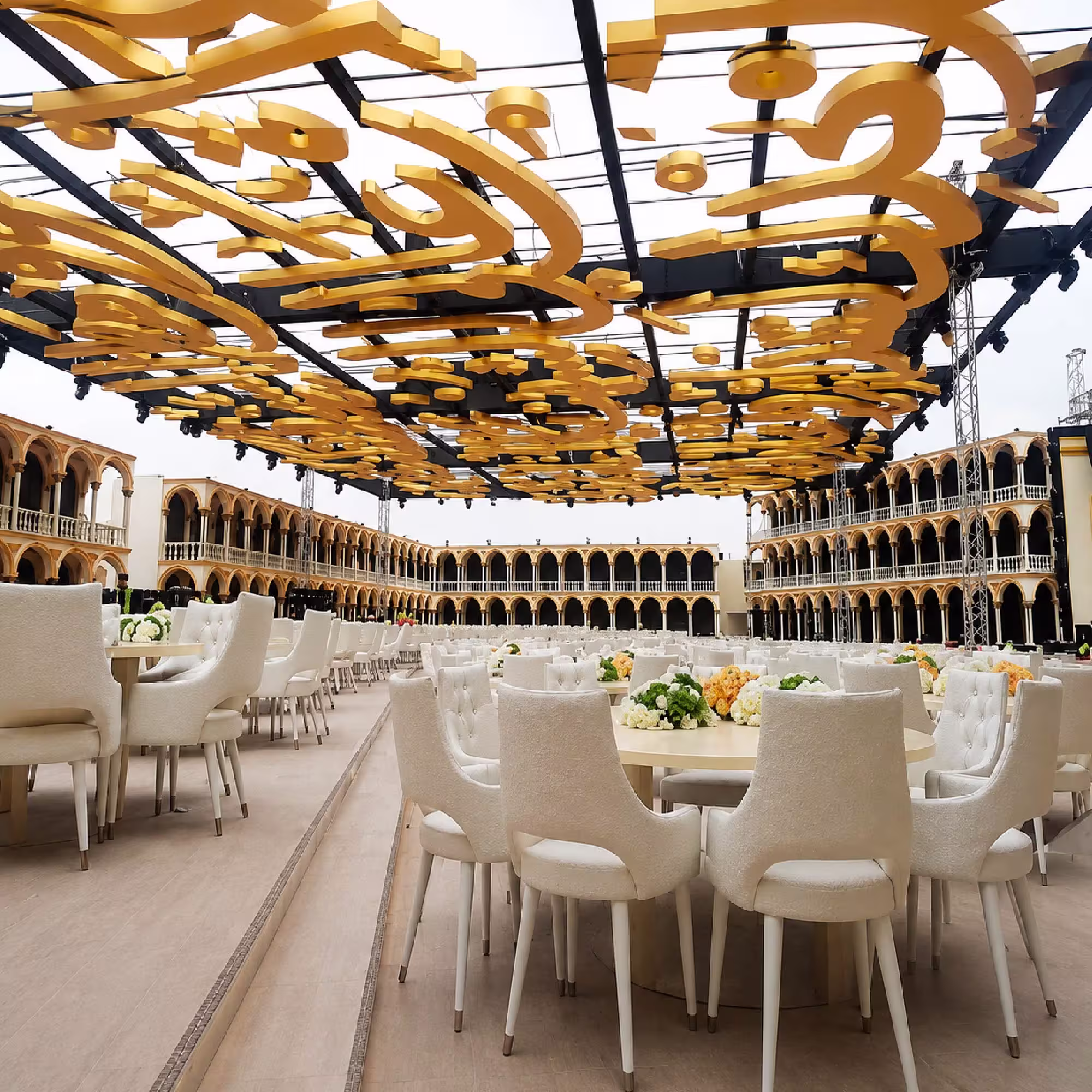 Luxury outdoor event setup with elegant seating and decorative gold ceiling structure
