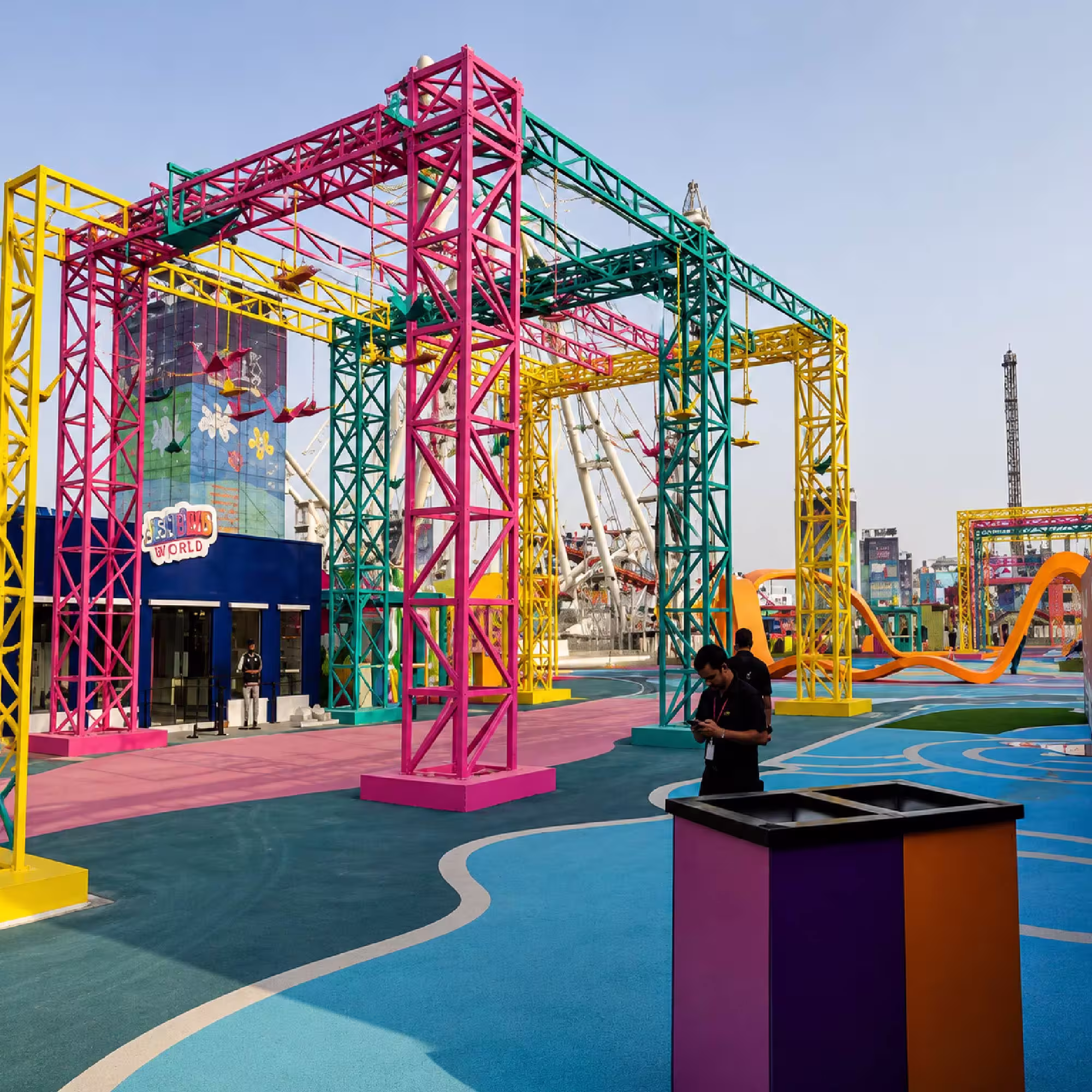 Colorful temporary event structures with aerial activity equipment at an outdoor entertainment venue