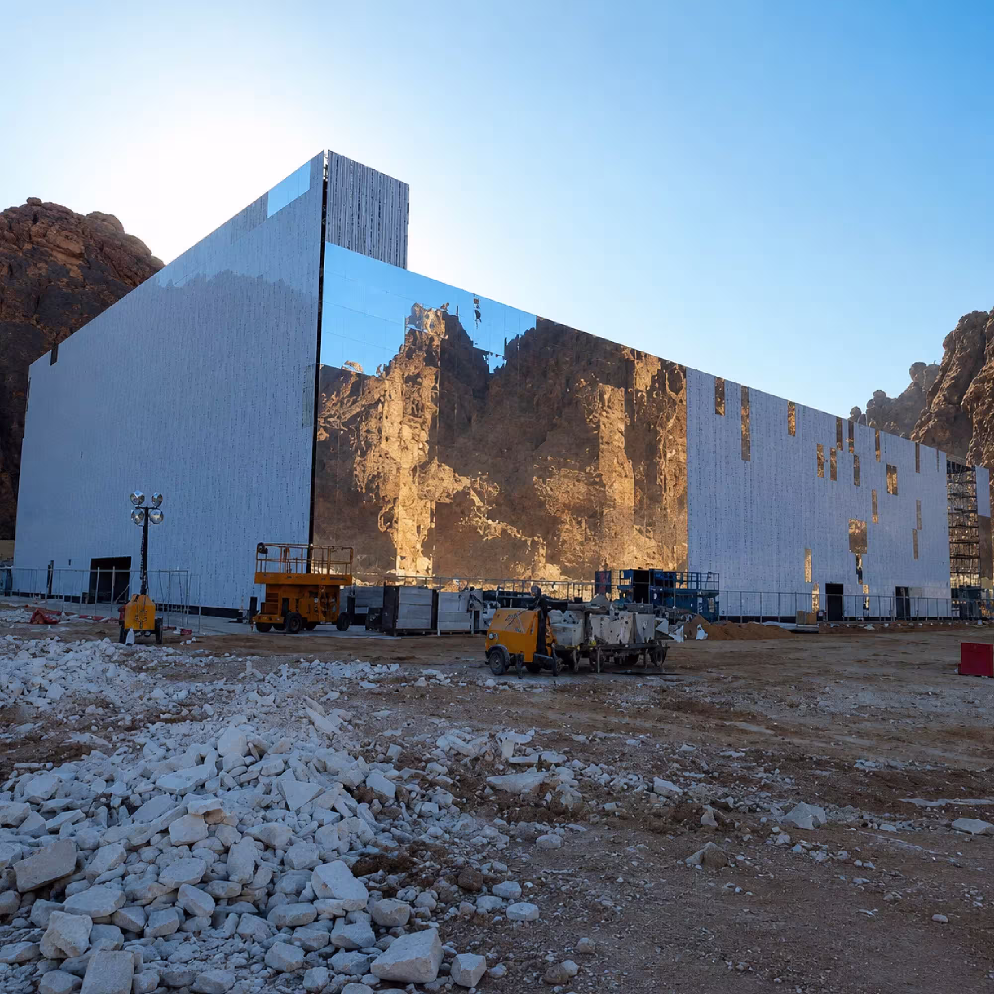 Large temporary structure under construction in a mountainous outdoor development site