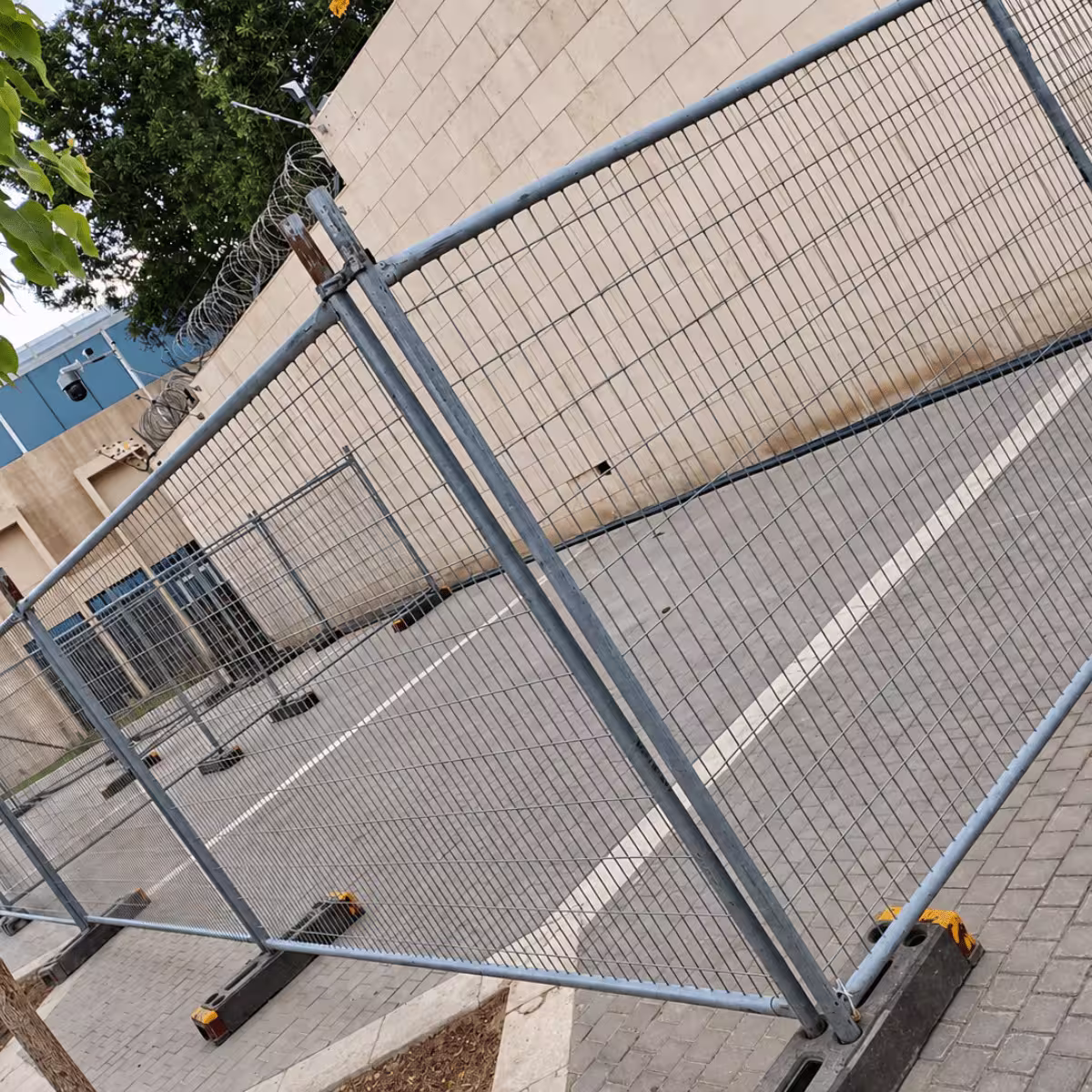 Temporary metal crowd-control fencing installed along a paved outdoor area.