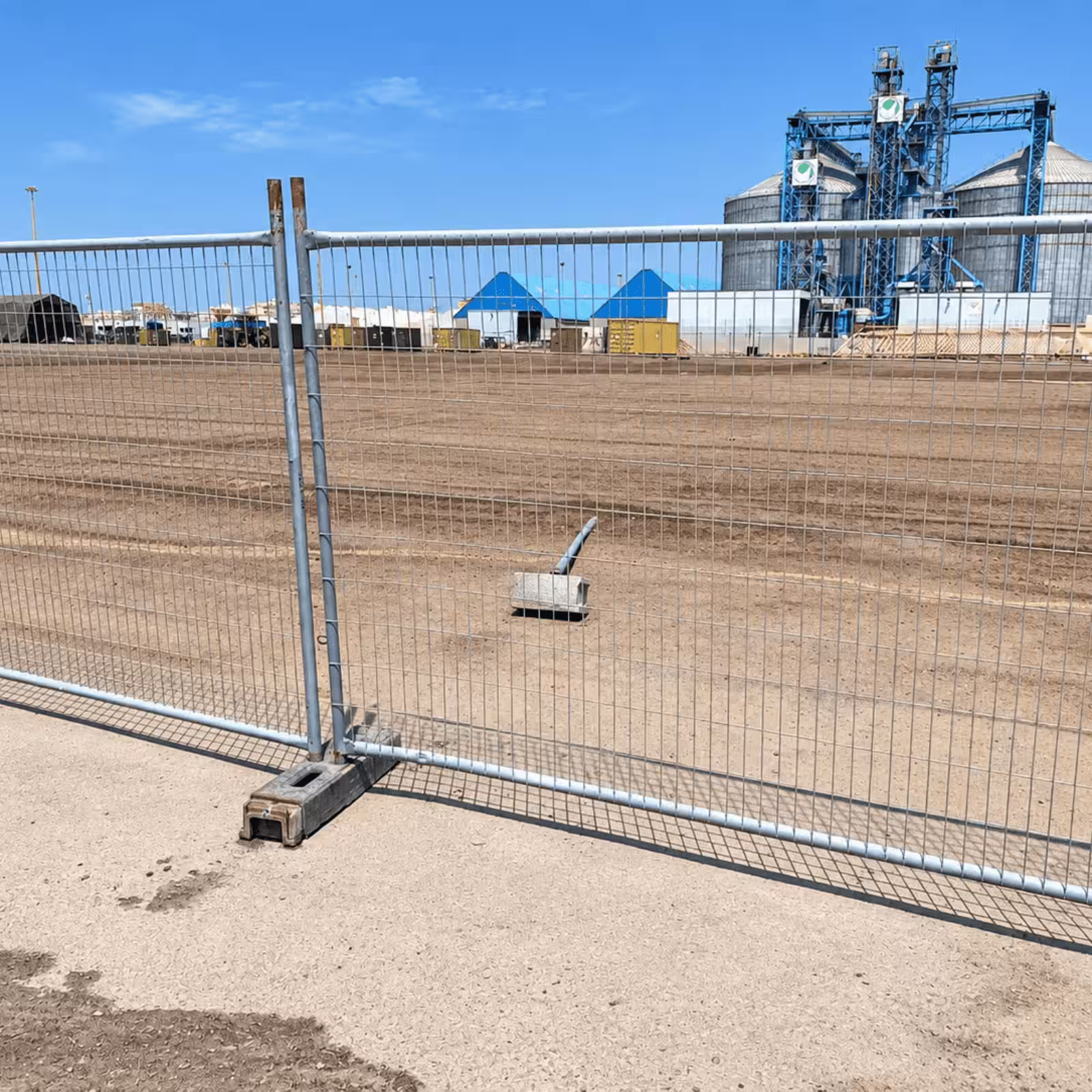 Temporary metal crowd-control fencing installed around an outdoor event or industrial site.