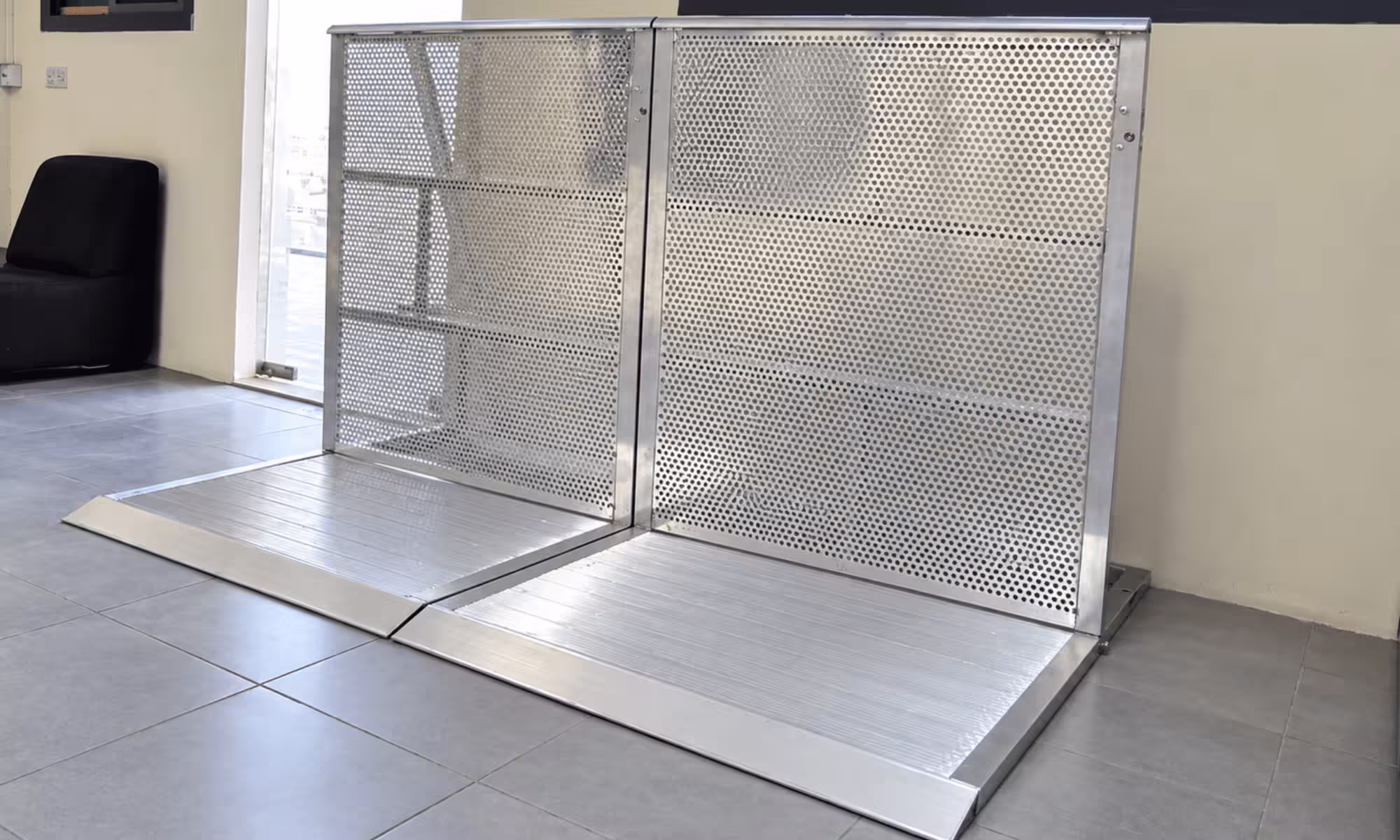 Portable aluminum accessibility ramp with perforated metal safety panels, designed for wheelchair and mobility access.